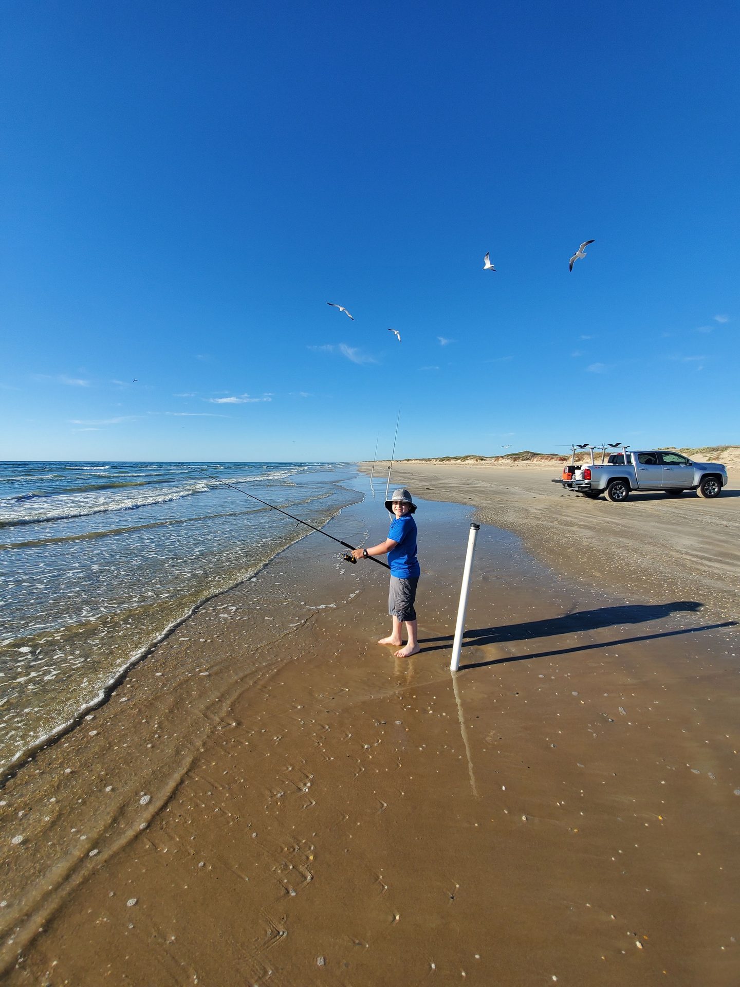 Young angler surf fishing on a Texas beach